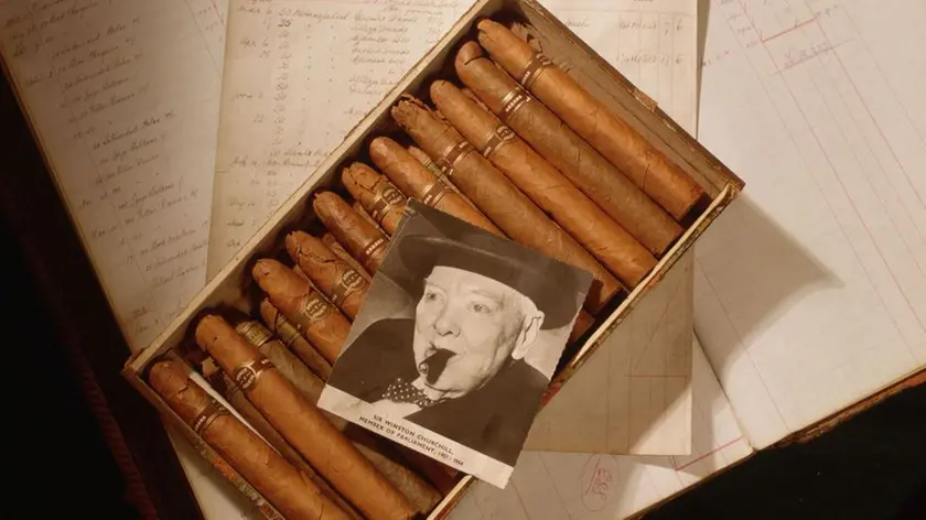 1990, London, England, UK --- A photograph of Sir Winston Churchill sits on a box of cigars and a 1940s ledger book. --- Image by © Nadia Mackenzie; Elizabeth Whiting & Associates/CORBIS