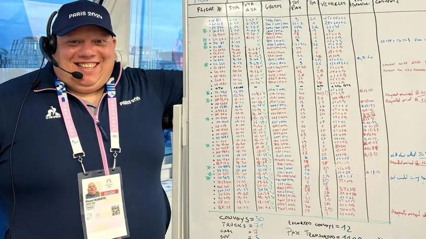 Alberto Pisani davanti al tabellone con gli arrivi da gestire alle Olimpiad