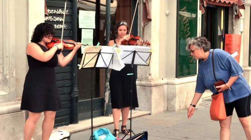 Due violiniste mentre suonano per strada