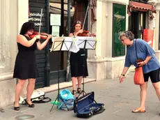 Due violiniste mentre suonano per strada