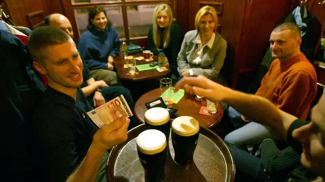 epa00894678 Customers at a pub use a 10 euro banknote to pay for their Guinness in downtown Ljubljana, Monday, 01 January 2007. Slovenia on Monday became the 13th country in Europe to adopt euro as common European currency. ANSA-EPA/STRINGER / PAL