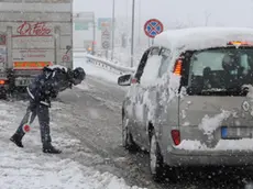 Agenti della polizia all'ingresso per l'autostrada A24 per Roma controllano che i veicoli siano dotati di pneumatici da neve o catene, Chieti, 3 febbraio 2012. ANSA / MASSIMILIANO SCHIAZZA