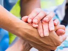 Nurse consoling senior woman holding her hand