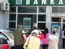 epa08387153 People wearing protective face masks queue in front of a bank office in Sarajevo, Bosnia and Herzegovina, 27 April 2020, amid the ongoing coronavirus COVID-19 pandemic. Countries around the world are taking increased measures to stem the widespread of the SARS-CoV-2 coronavirus which causes the COVID-19 disease. EPA/FEHIM DEMIR