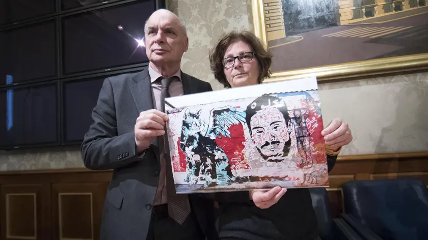 Claudio e Paola Regeni mostrano la foto di un murale fatto da writers egiziani su un muro di Berlino che raffigura il volto di Giulio Regeni con un gatto stilizzato durante la conferenza stampa all'interno della sala Nassiria a Palazzo Madama 4 aprile 2017 a Roma.ANSA/MASSIMO PERCOSSI