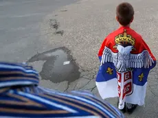 A boy with an old Montenegro flag attends during a protest after arrest of the Serbian Orthodox Church priests in Montenegro, in Belgrade, Serbia, Thursday, May 14, 2020. Montenegrin police said Thursday they have detained around 60 people following clashes at protests demanding the release of eight Serbian Orthodox Church priests jailed for leading a religious procession despite a ban on gatherings related to the new coronavirus outbreak. (AP Photo/Darko Vojinovic)