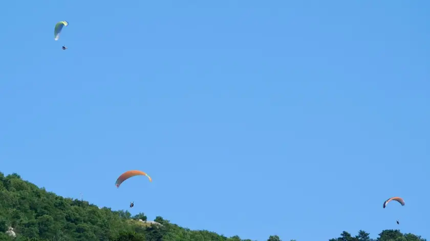 Appassionati mentre si lanciano con il parapendio questo pomeriggio, sabato 13 luglio, dal monte Carso. Foto Massimo Silvano