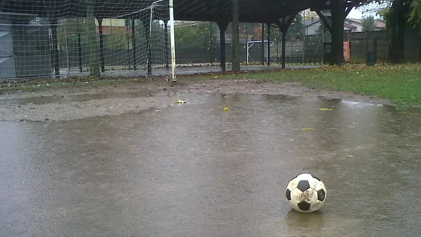 Un pallone da calcio in una pozzanghera d'acqua (Foto tratta da Internet)