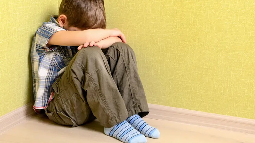 Un bambino piange in un angolo