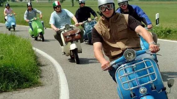 25 Jul 2004, Osterhofen, Baden-Wuerttemberg, Germany --- A group of people ride Italian Vespa motor scooters on a road. --- Image by © Rolf Schultes/dpa/Corbis
