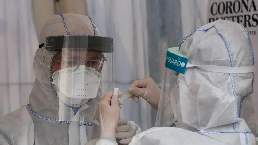 Health professionals wearing protective gear, face shield and face mask label a saliva sample at a drive-in COVID-19 testing facility in Berlin on April 30, 2020, amid the new coronavirus COVID-19 pandemic. - The testing facility, set up by the health authority of Berlin's Mitte district and operational since March 23, 2020, can administer over 150 tests a day, five days a week. (Photo by John MACDOUGALL / AFP)