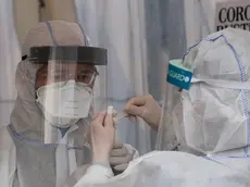 Health professionals wearing protective gear, face shield and face mask label a saliva sample at a drive-in COVID-19 testing facility in Berlin on April 30, 2020, amid the new coronavirus COVID-19 pandemic. - The testing facility, set up by the health authority of Berlin's Mitte district and operational since March 23, 2020, can administer over 150 tests a day, five days a week. (Photo by John MACDOUGALL / AFP)