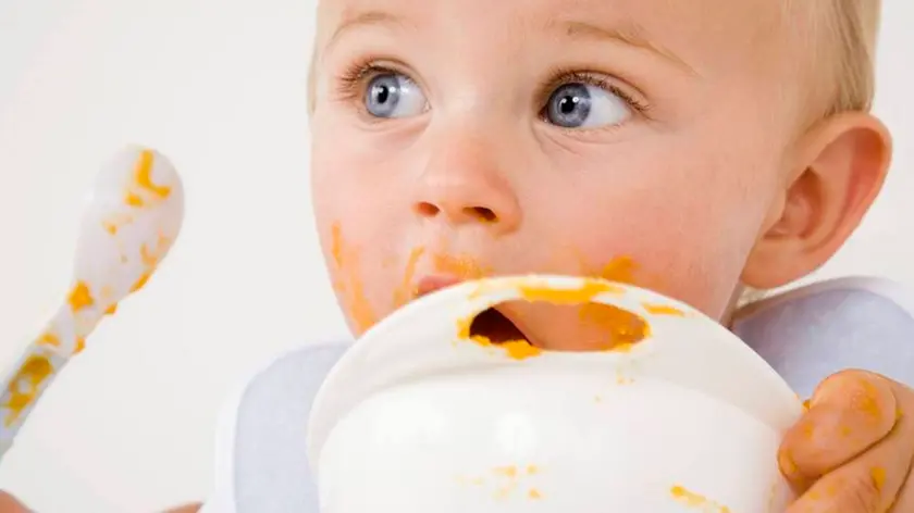 Un bambino alle prese con un piatto di minestra in una foto di archivio