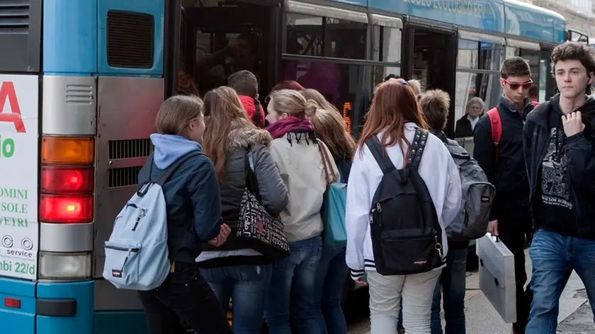 Ragazzi in fila alla fermata dell'autobus