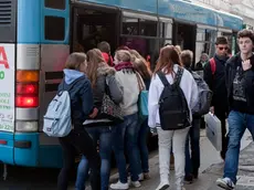 Ragazzi in fila alla fermata dell'autobus