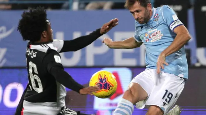 epa08087258 FC Juventus' Juan Cuadrado (L) and SS Lazio's Senad Lulic (R) in action during the SuperCoppa Italiana match between Juventus and SS Lazio at King Saud University Stadium, Al-Riyadh, Saudi Arabia, 22 December 2019. EPA/FARIS GHAITH