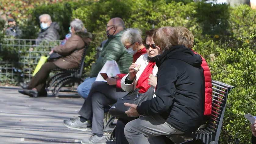 Panchine occupate, chiacchiere tra conoscenti e gruppetti di clienti davanti ai bar che servono caffè e bevande solo per asporto. Scene simili ieri c’erano un po’ in tutti i rioni di Trieste. Foto Bruni e Lasorte