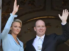 Il saluto del principe Alberto di Monaco e la principessa Charlene, i una foto dell'1 luglio 2011 a Monaco. Assai poco romantica la luna di miele.sudafricana della principessa Charlene Wittstock e del suo Alberto II di Monaco: i neo sposini - a quanto riferisce il tabloid britannico The Sun - non solo dormono in camere separate, ma addirittura in alberghi diversi distanti l'uno dall'altro una quindicina di chilometri. . EPA/BRUNO BEBERT/POOL