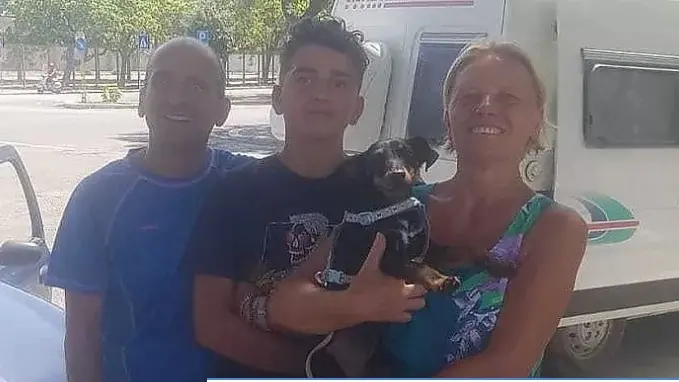 Mauro, Alessio e Martina con il cagnolino Ugo in braccio e il camper sullo sfondo. Foto La Repubblica