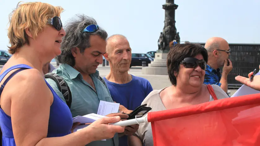 Lo sparuto gruppetto di manifestanti davanti alla Prefettura di Trieste (foto Lasorte)