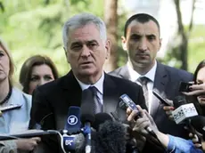LaPresse.20-05-2012.Politica.Elezioni Serbia, ballottaggio per le presidenziali...Tomislav Nikolic, center, the nationalist Serbian Progressive Party leader and presidential candidate, talks to members of the media after casting his ballot at the presidential runoff elections, as his wife, Dragica, left, looks on in Belgrade, Serbia, Sunday, May 20, 2012. Serbians voted Sunday in a presidential runoff election that pits pro European Union Boris Tadic against nationalist Tomislav Nikolic who wants closer ties with Russia and is threatening protests if he loses because of alleged ballot rigging.