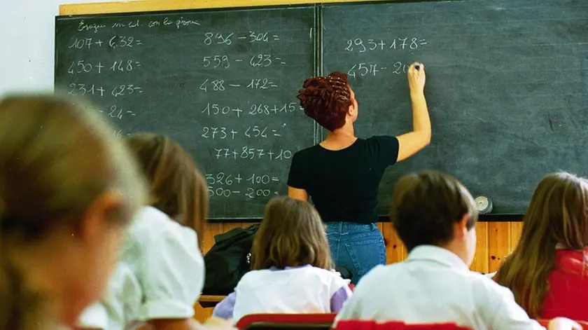 Un’insegnante alla lavagna durante una lezione in classe