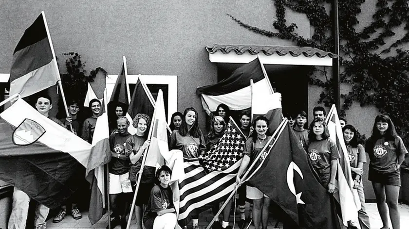 Gli studenti del Mondo unito con le proprie bandiere in una foto degli anni Novanta tratta dall’archivio digitale del “Piccolo"