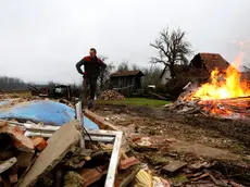 epa08918705 A man stands in front his destroyed house and burns debris in the Majske Poljane village near Glina, 04 January 2021. The 6.4 magnitude earthquake that struck Croatia on 29 December 2020 left many houses in Petrinja, Sisak and the Glina area damaged or destroyed and another 4.2 magnitude aftershock was measured earlier on 04 January 2021. The 29 December 2020 earthquake left numerous people injuried and at least seven people dead. EPA/ANTONIO BAT