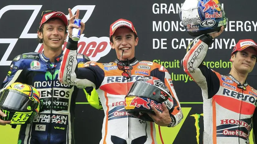 epa04258880 Spanish MotoGP rider Marc Marquez (C) celebrates his victory next to runner-up Italian Valentino Rossi (L), and third-placed Spanish Dani Pedrosa (R) at the Motorcycling Grand Prix of Catalunya held at Montmelo circuit in Barcelona, northeastern Spain, 15 June 2014. EPA/ANDREU DALMAU