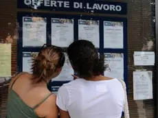 Ragazze consultano le offerte di lavoro nella bacheca di un'agenzia interinale