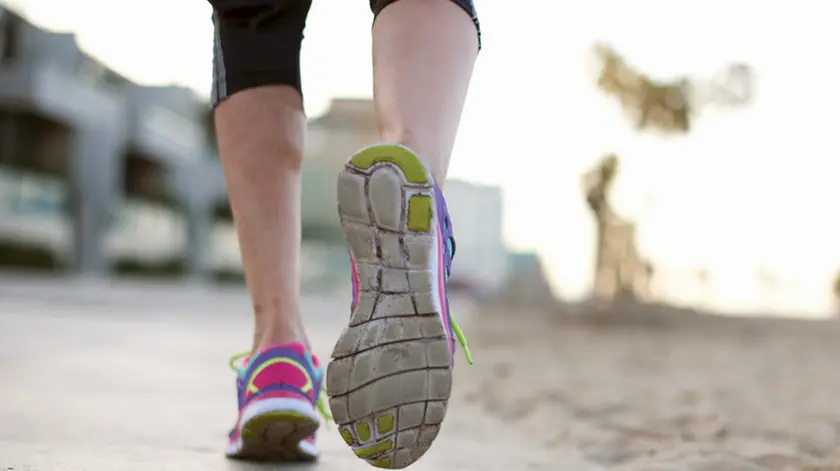 Low section rear view of woman jogging wearing training