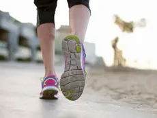 Low section rear view of woman jogging wearing training