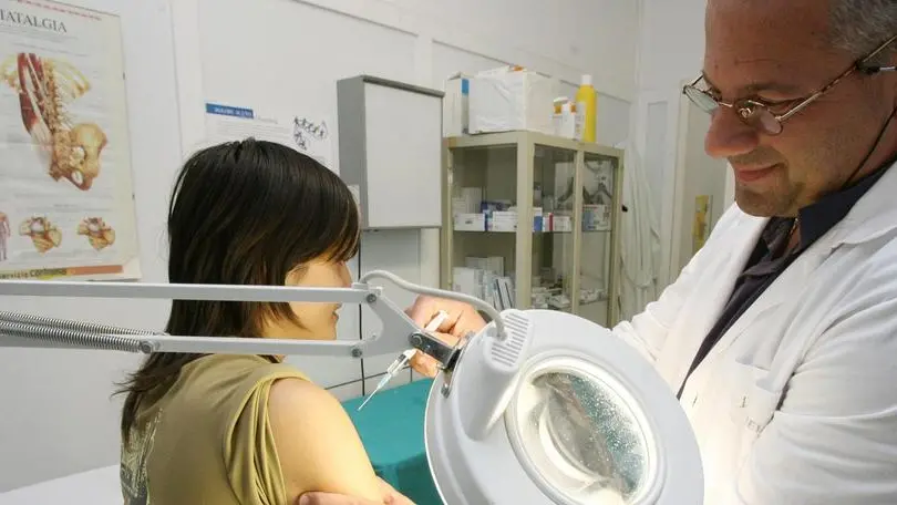 Un medico di base mentre visita una paziente
