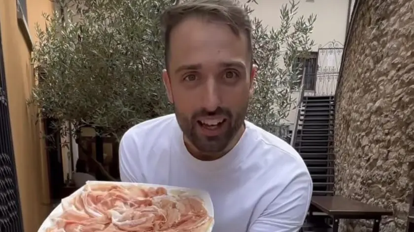 Eric Battistel con dei piatti di prosciutto crudo