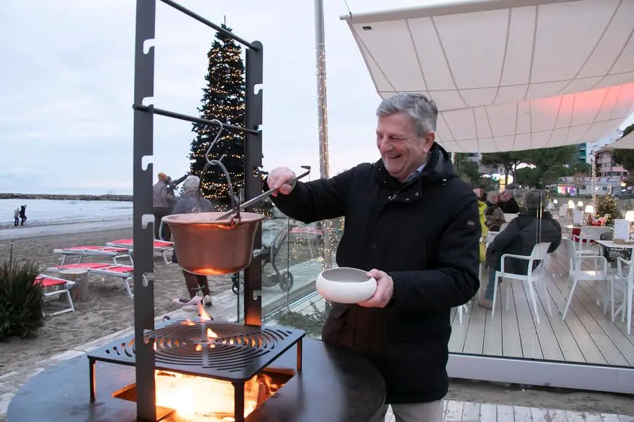 il presidente della Git Marin mentre testa il pentolone con la minestra di fagioli sopra la cucina a legna dove saranno grigliati pesce e carne in riva al mare Foto Bonaventura