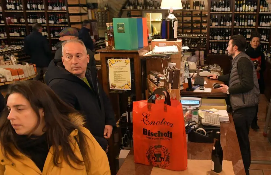 Un’enoteca affollata in centro città per le compere Foto Bruni