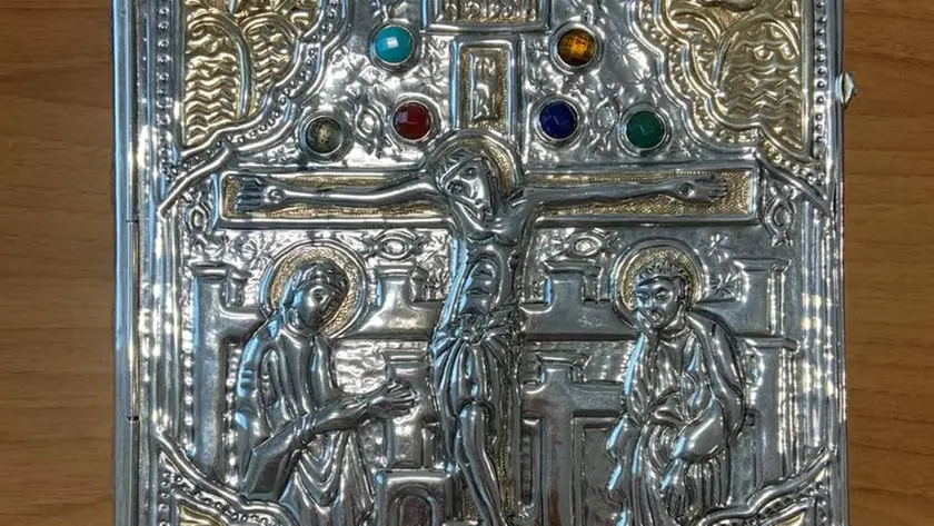 Il testo sacro protetto da una preziosa copertina in argento che ritrae Cristo in croce