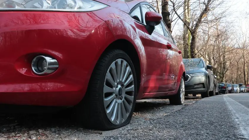 Le auto con le gomme tagliate in via al Cacciatore a Trieste. Foto Lasorte