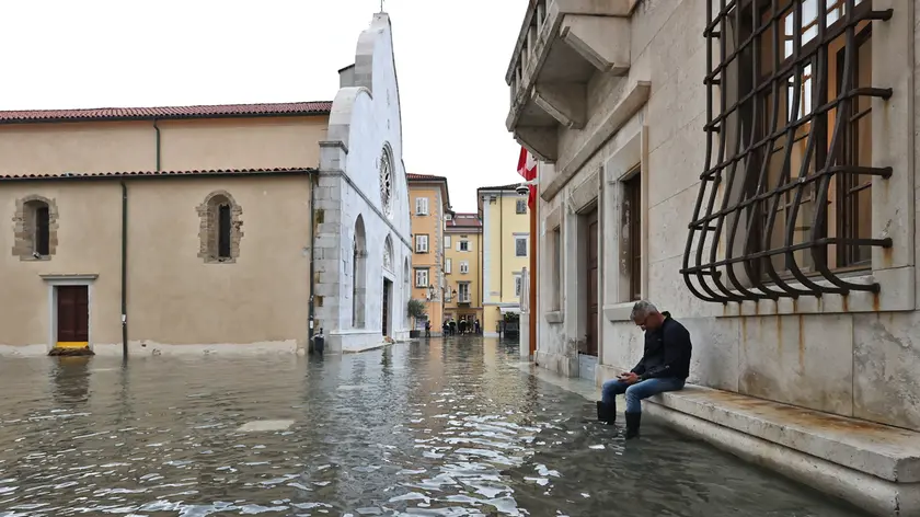 Un residente durante l’acqua alta che ha colpito Muggia lo scorso autunno Foto Lasorte