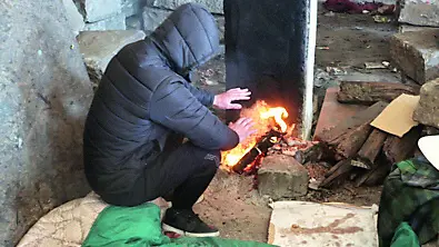 Un migrante si scalda con un falò Foto Lasorte