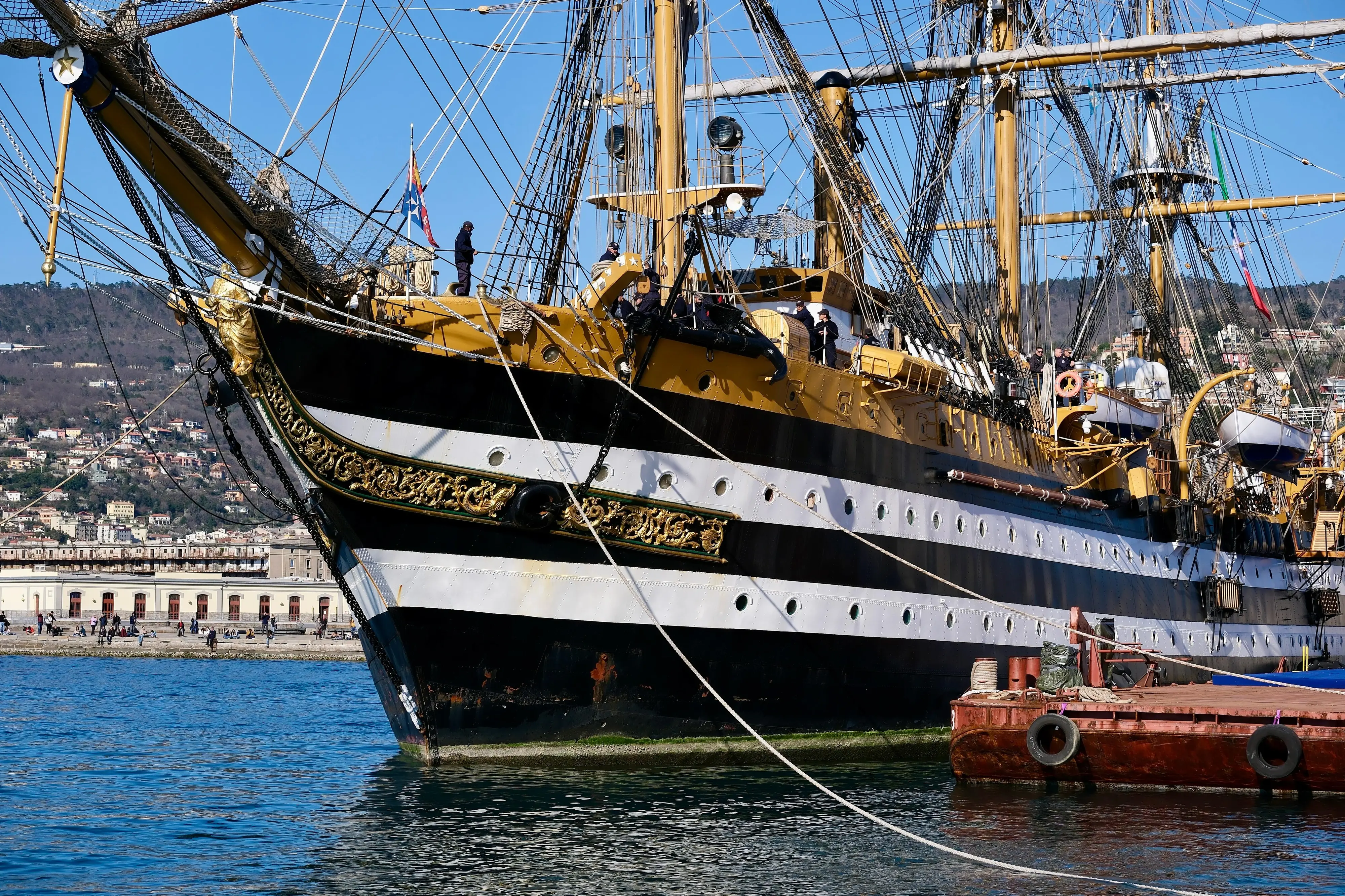 Il veliero Vespucci ha mollato gli ormeggi dalle Rive di Trieste e si è trasferita all'Arsenale del porto cittadino. Tre fischi di sirena in segno di saluto a Trieste, la città che l’ho accolto festosamente al rientro del tour mondiale. Alle 15 di martedì 4 marzo la nave scuola della Marina Militare si è allontanata dalla Riva del Mandracchio e si è lasciata alle spalle piazza Unità d’Italia, dopo tre giorni di celebrazioni. Centinaia di triestini e turisti sono accorsi sulle Rive e sul Molo Audace per salutare quella che è considerata la nave più bella del mondo. Impossibile replicare il bagno di folla che l’ha accolta domenica all’arrivo, con tanto di passaggio delle frecce tricolori. Ma in tanti hanno voluto essere presenti alla partenza. Due rimorchiatori hanno girato il vascello, con manovre morbide e precise, quasi a passo di danza. L’impressione, da terra, era di osservare un carillon silenzioso che in qualche minuto ha permesso al veliero di puntare la prua verso l’Adriatico, pronto per il tour Mediterraneo. Prima di allontanarsi, il saluto alla città. Tre fischi di sirena e i marinai che sventolano mani e cappelli. Trieste ricambia con lo stesso affetto e sulle Rive scroscia un applauso che suona come un arrivederci. Notizia di Maria Elena Pattaro foto di Massimo Silvano