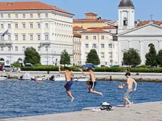 Tre ragazzi si lanciano dal molo Audace (foto Lasorte)