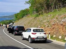 Veicoli in coda lo scorso weekend a Cherso per raggiungere lo scalo traghetti di Faresina. foto Novi list