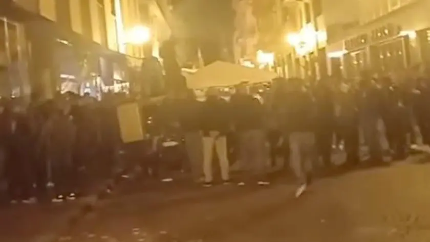 Un fermo immagine del video circolato sui social in cui diverse decine di persone, tra cui diversi con il cappello con la penna nera, intonano "Faccetta Nera" al raduno degli Alpini a Biella