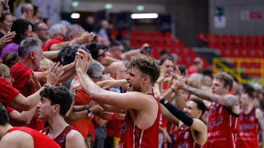 I giocatori di Trieste festeggiano con i tifosi presenti a Verona dopo la vittoria su Sassari (Foto Ciamillo/Lasorte)