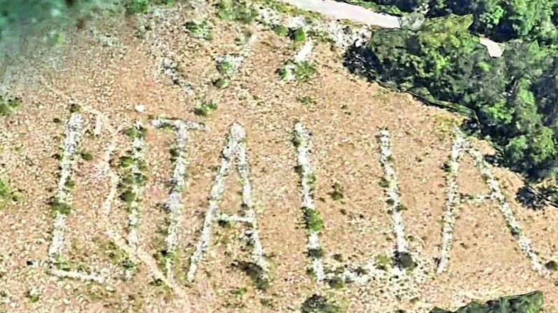 La scritta Tito sulla sommità del Sabotino e, in alto, W l’Italia che Fratelli d’Italia intende valorizzare