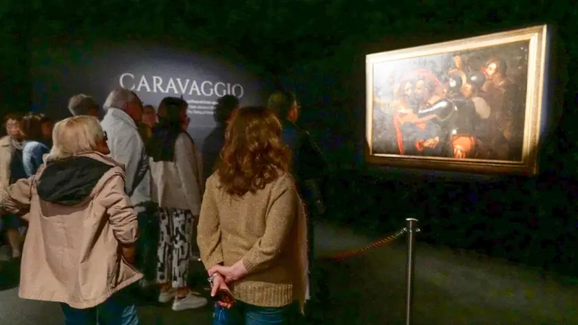 Visitatori davanti al dipinto di Caravaggio (Marega)