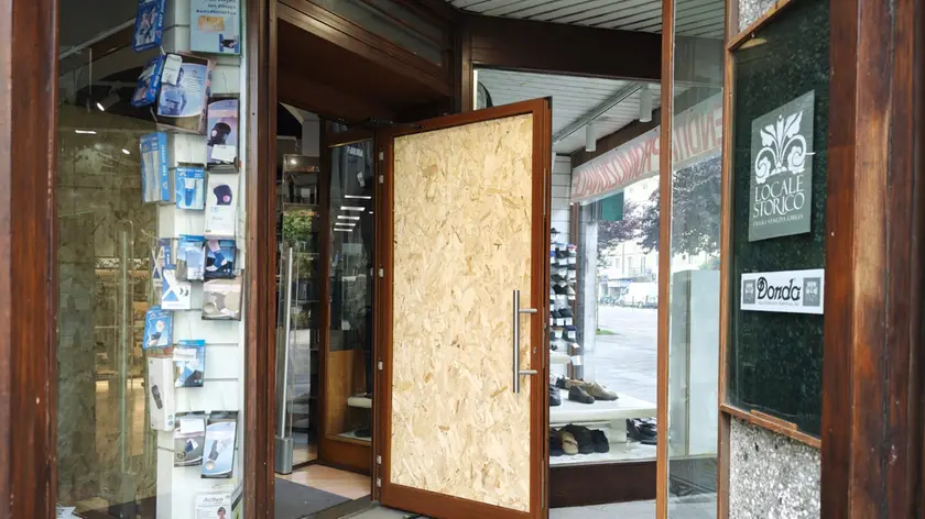 La porta di ingresso del negozio Donda: un pannello sostituisce temporaneamente il vetro. Foto Lasorte