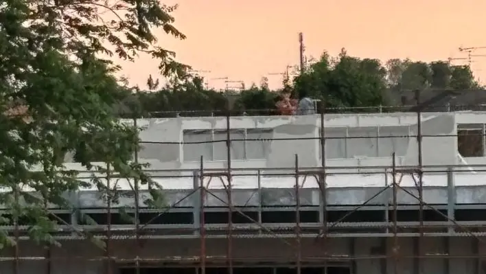 La sagoma di uno dei tre ragazzi sul tetto della scuola in costruzione