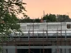 La sagoma di uno dei tre ragazzi sul tetto della scuola in costruzione
